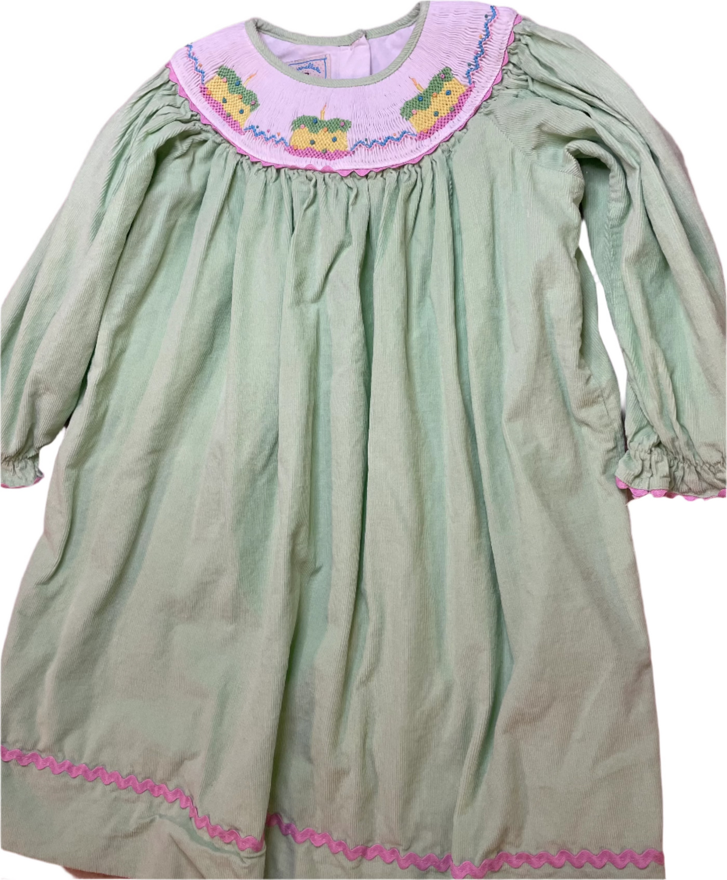 Light green long sleeve girl's dress with smocked yoke and pink trim, featuring pumpkin embroidery.