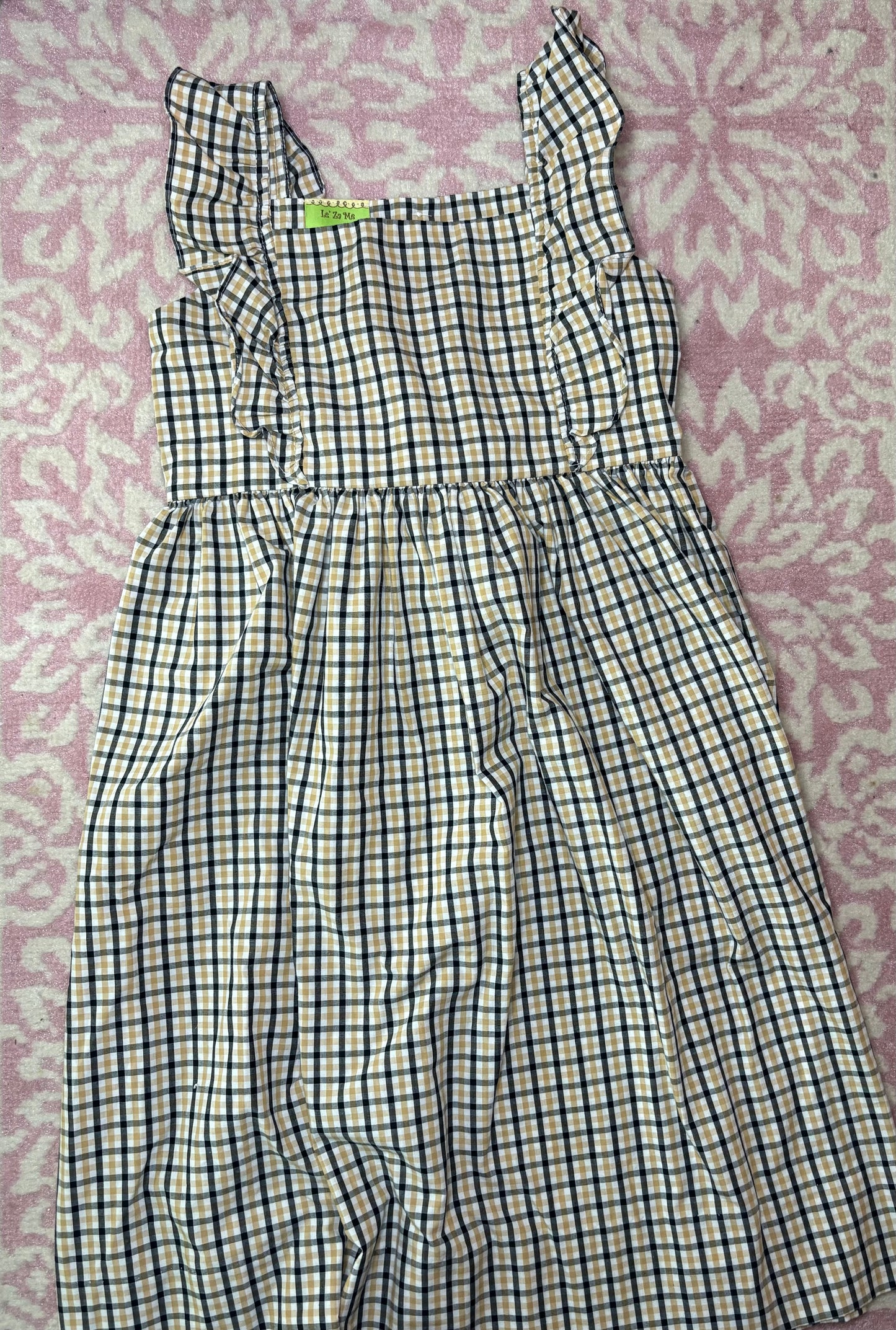 Girls' ruffle strap dress with blue and tan plaid pattern on pink floral background