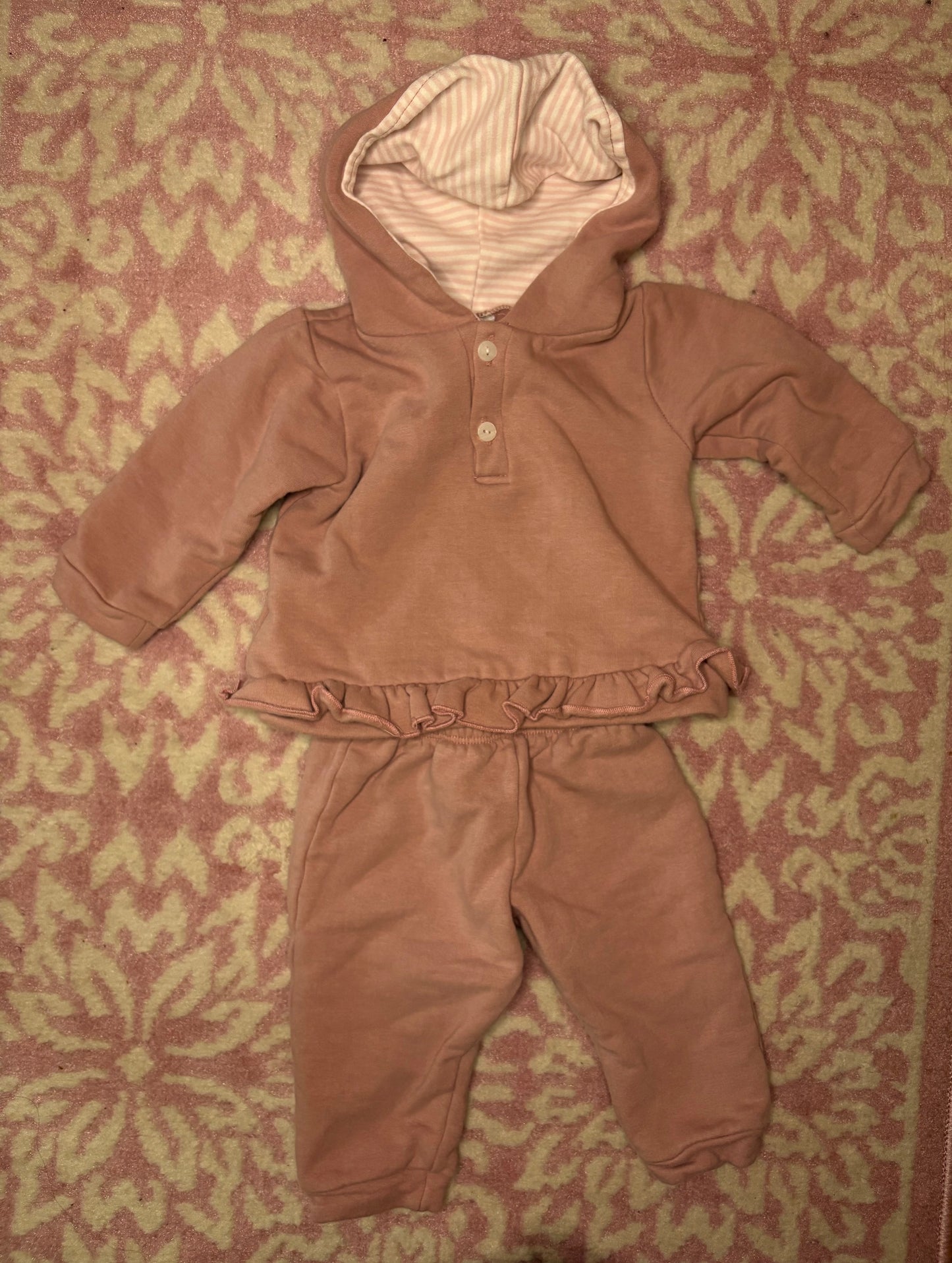 Pink toddler hooded ruffle lounge set with striped lining on patterned carpet