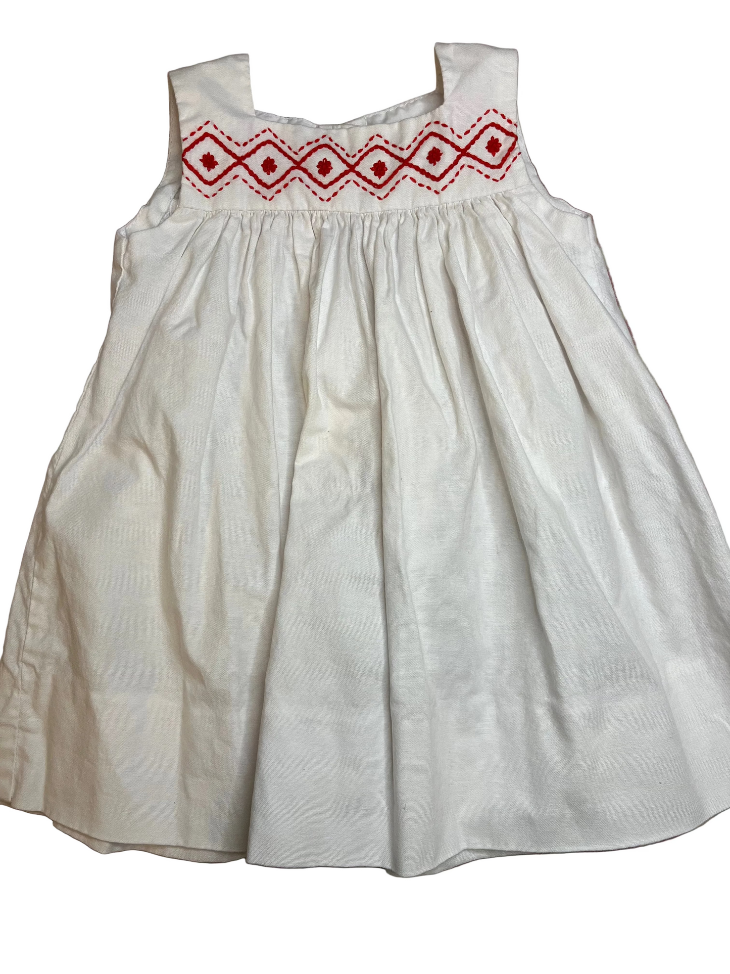 White sleeveless girls dress with red embroidered geometric trim on bodice