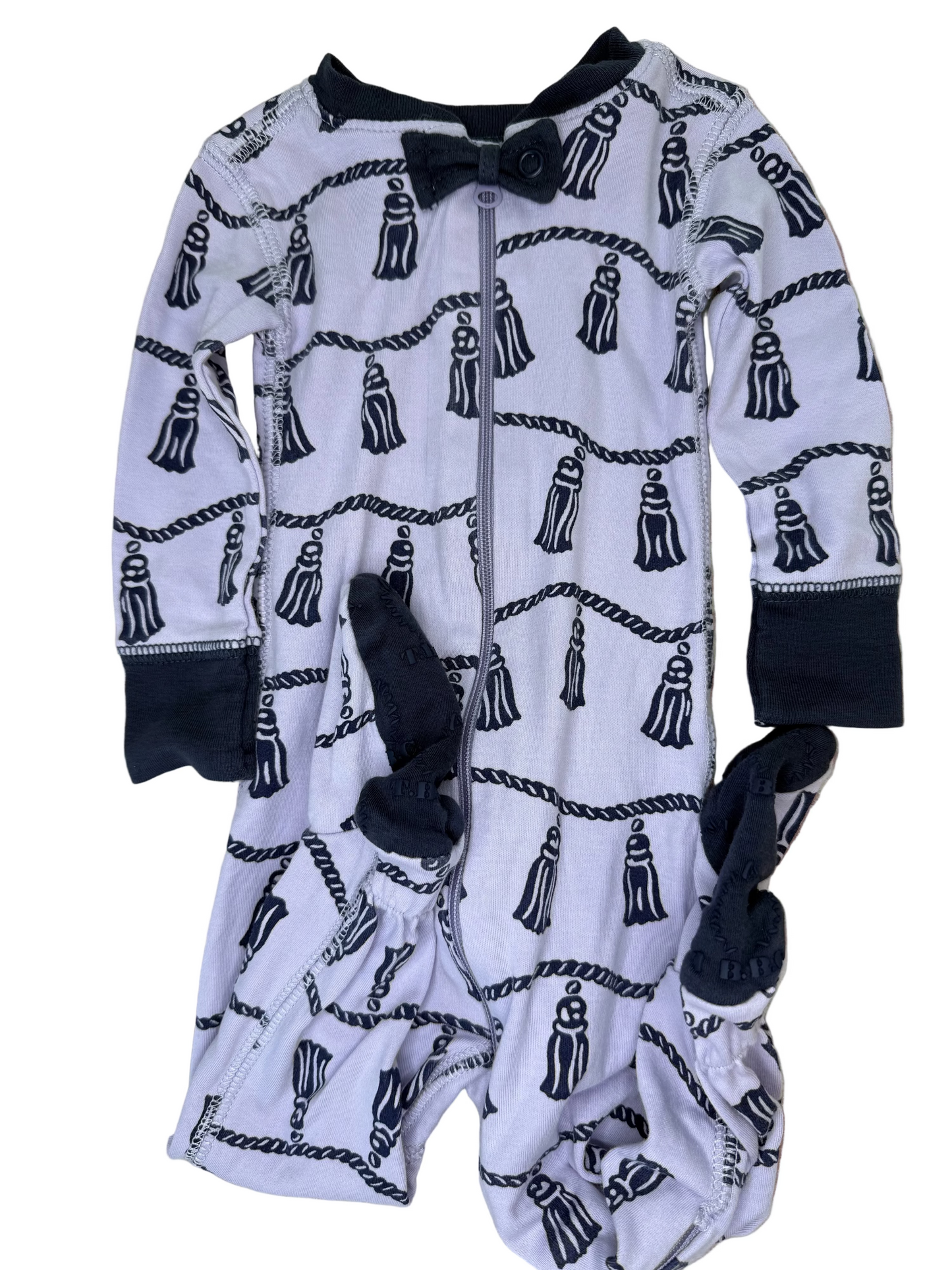 Navy and white baby footed romper with rope and tassel pattern, front zipper, and bow tie detail