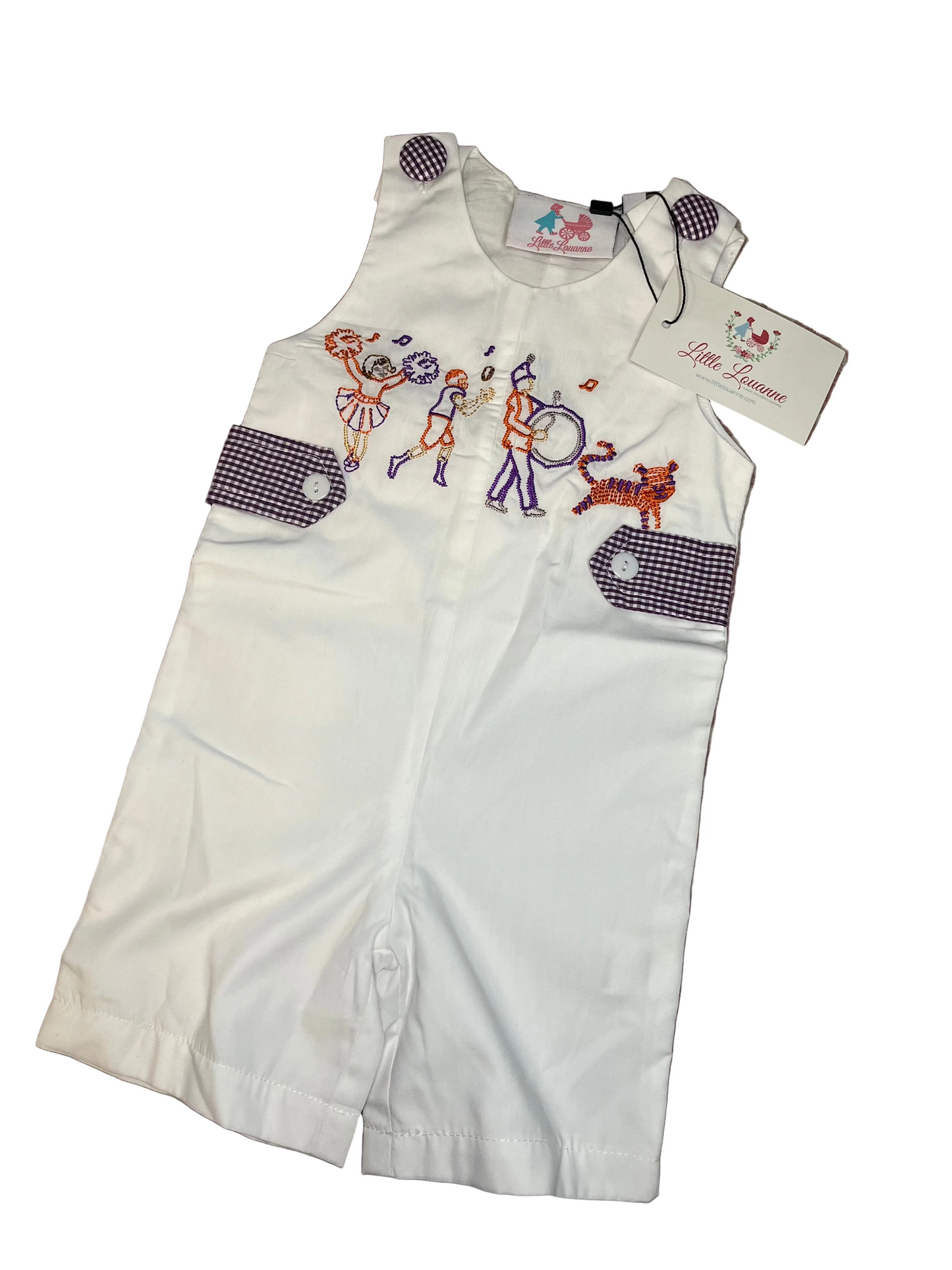 White toddler romper with purple gingham trim and embroidered parade scene on the chest