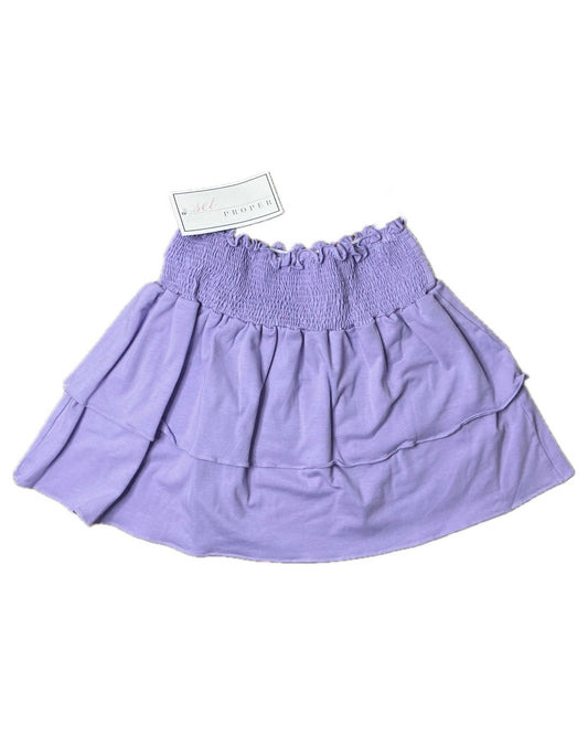 Lavender tiered ruffle children's skirt with smocked waistband, laid flat on white background