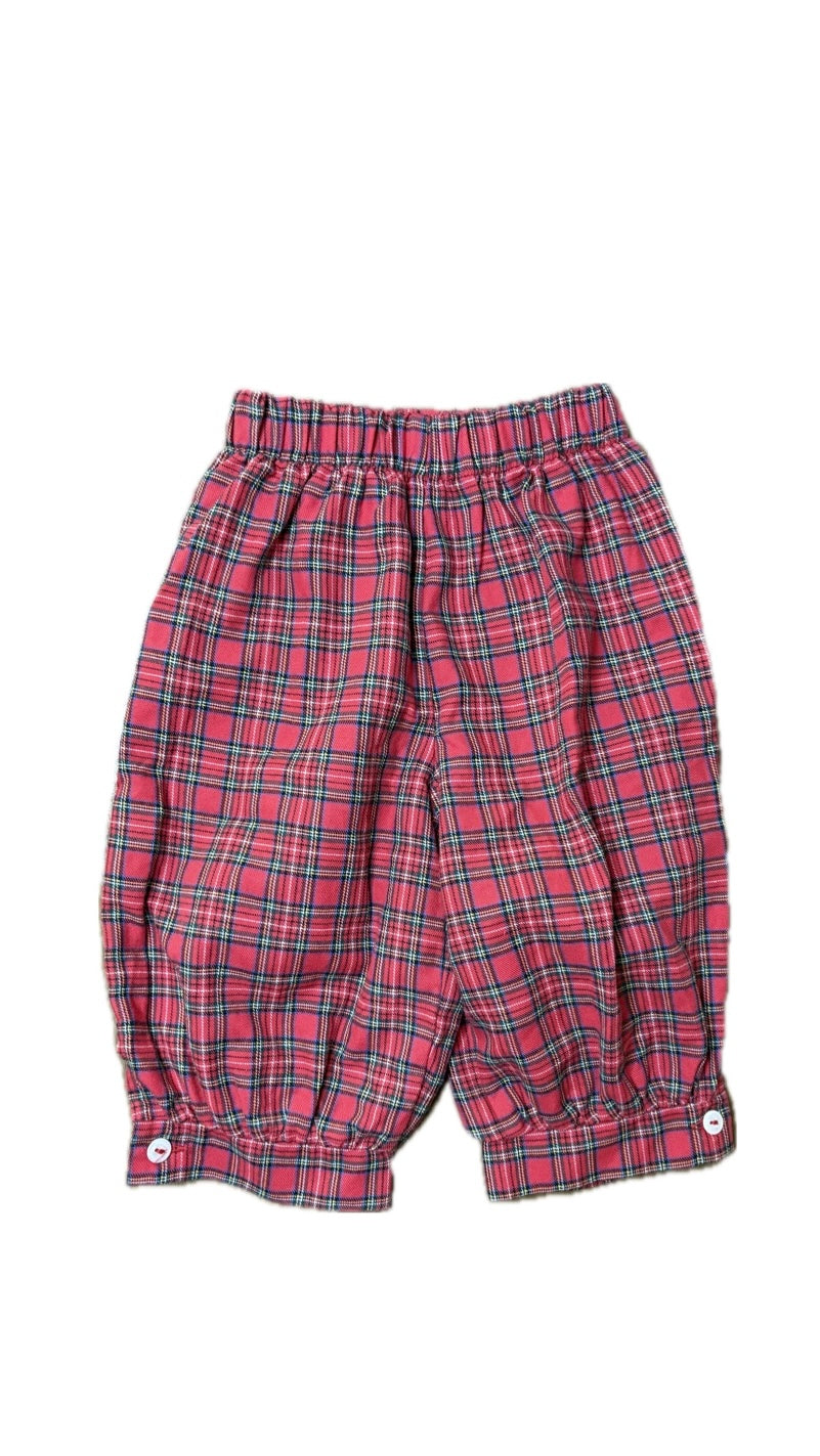 Red plaid cotton children’s pants with elastic waistband and button cuffs on white background