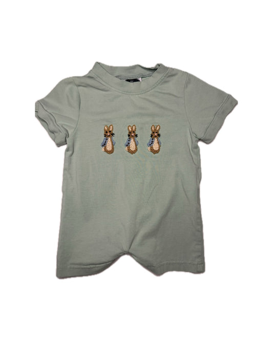 Green t-shirt with embroidered bunnies on a white background