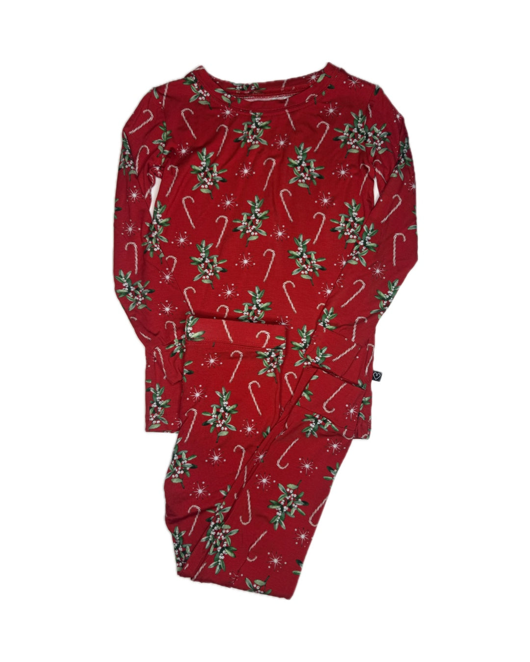 Red children’s Christmas pajamas with candy cane and mistletoe print on white background