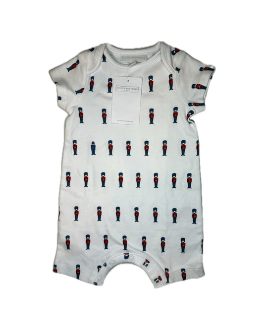 White baby romper with red and blue toy soldier print and snap closures